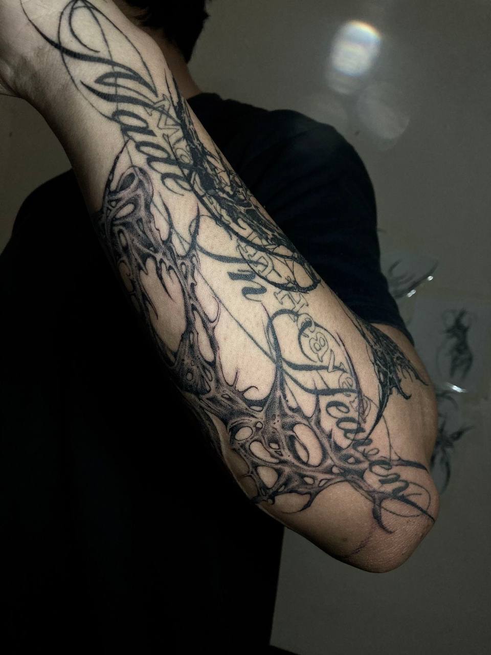 Ornamental script elbow tattoo